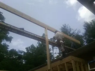 Carpenter setting a ridge beam over a new addition frame — Ice Dam Removal by Roofing Brothers in Elbow Lake