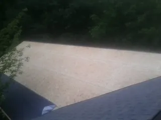 New OSB roof sheathing installed beside an existing shingle roof in Elbow Lake