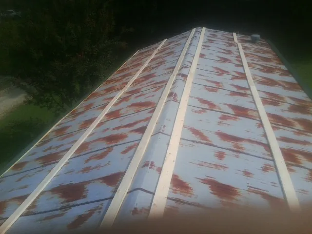 Rusted metal roof panels with new wood purlins before replacement — Storm Damage Roof Repair in Elbow Lake by Roofing Brothers