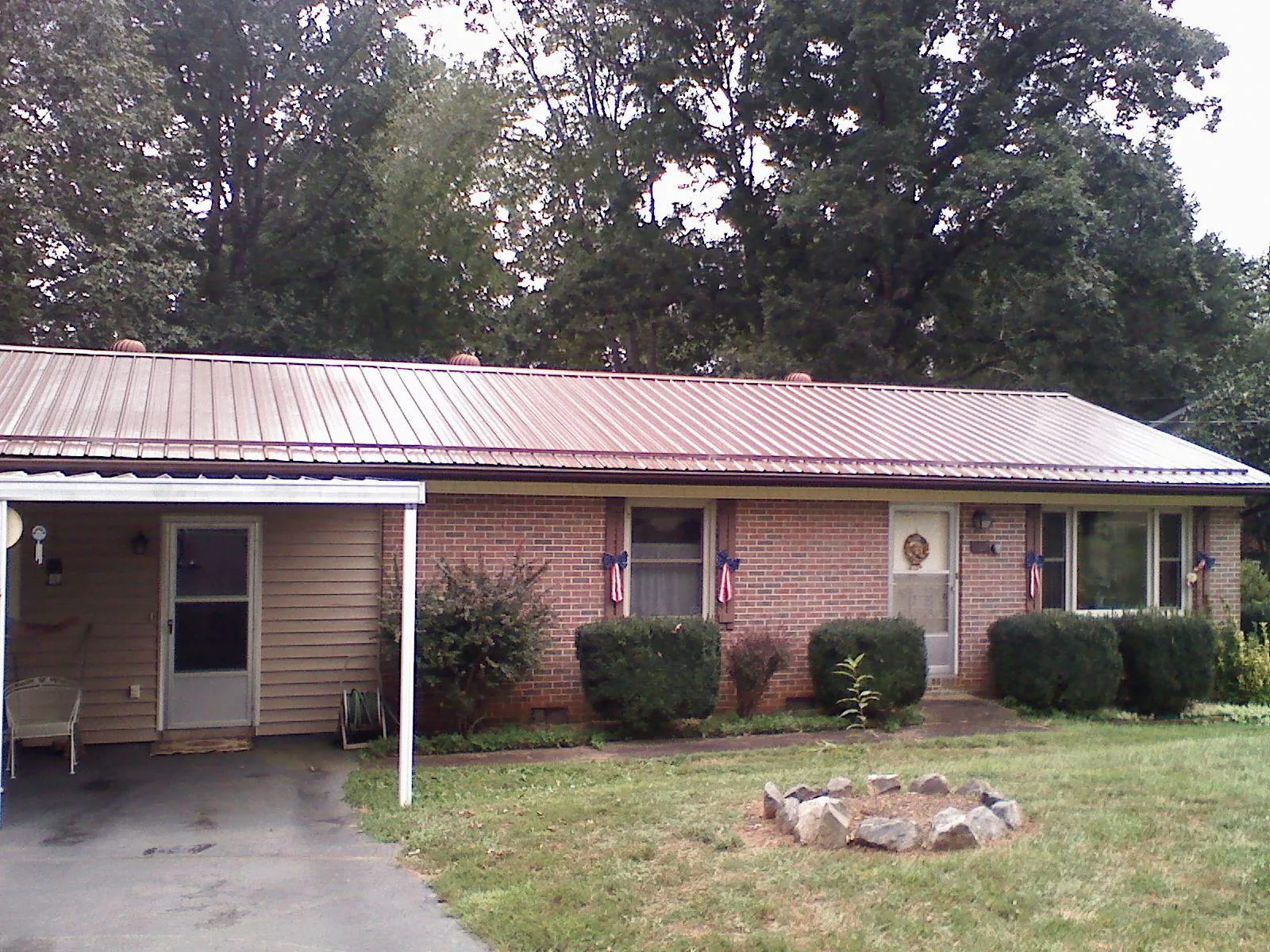 Bronze metal roof and carport on a brick ranch home — Roof Repair work by our crew in Elbow Lake